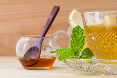 一杯草药茶 鲜绿色薄荷 蜂蜜和柠檬加木头液体叶子美食玻璃芳香杯子草本植物香料药品康复图片