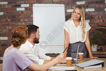 在会议桌旁的女商务人士介绍情况图片