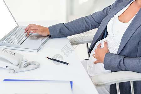孕妇在打手提笔记本电脑时触摸肚子图片
