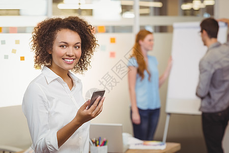 使用移动电话的微笑商业女商务人士幸福职员合伙设计师讨论头脑设计电话女性平板图片