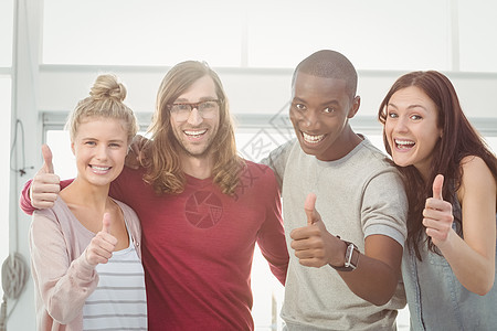 微笑的商业团队的肖像 举起拇指和手围着图片