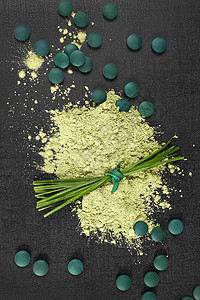 氯 螺旋藻和麦草黑色绿色小球藻药品背景粉末排毒小麦药丸维生素图片