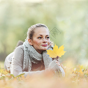秋天公园的女人喜悦微笑女孩森林女性黄色快乐享受女士叶子背景图片