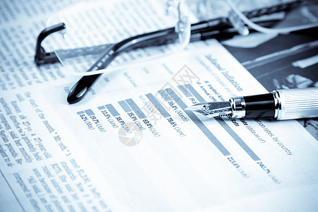 笔和墨镜旁边的财务图表和图表文档利润报纸圆珠笔生长风险公司经济计算器预报图片