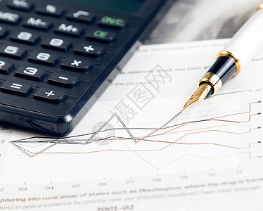 笔和计算器旁边的财务图表和图表经济生长圆珠笔眼镜预报办公室数字贸易利润笔记本图片