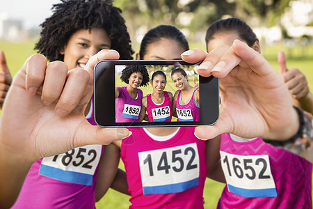 手持智能手机显示的复合图象快乐手势护理晴天乳腺癌运动员竞赛友谊展示健康图片