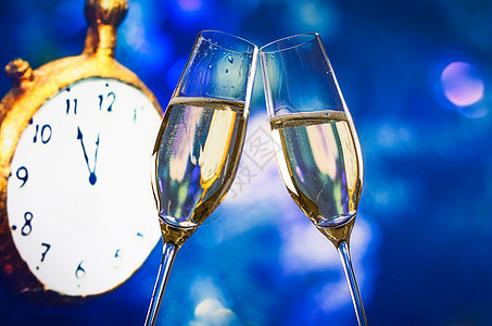 新年或圣诞节在午夜时分 香槟笛声响起欢呼 蓝bookeh和钟图片