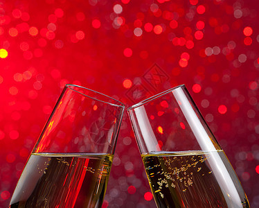 红光bokeh背景上带有金泡的香槟长笛气泡嘶嘶纪念日干杯装饰周年饮料奢华派对庆典图片