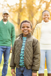 一个小男孩在背景里 和他父母对抗环境快乐活动男性母亲幸福公园儿子童年父亲图片