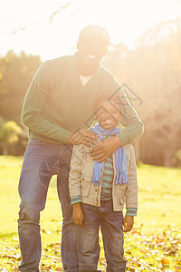 父亲和儿子的肖像男生树叶微笑草原孩子男性活动娱乐性幸福保暖图片