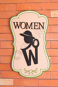厕所砖墙上的现代标志 文字“妇女”图片