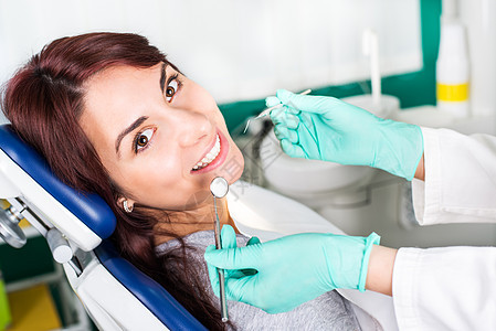 牙医时的微笑妇女专业考试女性检查健康手术设备镜子牙齿快乐图片