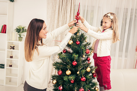 母亲和多格特装饰圣诞树装潢孩子假期新年庆祝家庭女士红色女儿圣诞图片