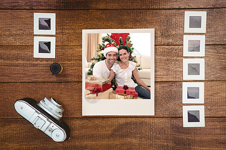 喜悦情侣在家里庆祝圣诞节的复合形象 在家庭家长幸福相机女士礼物团体照片时间房子图片