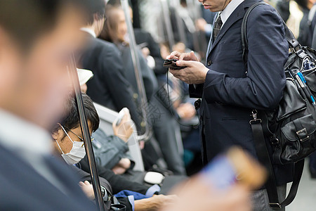 商业人士在东京地铁旅行过境都市手机航程成人游客高峰民众火车工作图片