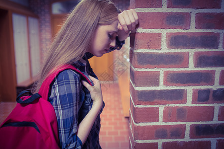紧靠墙壁的担心学生女孩悲伤悲哀焦虑教育知识更衣室大学服装储物柜图片