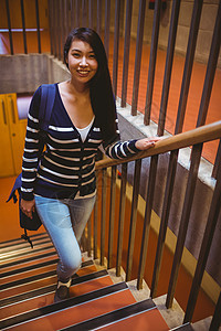 微笑的学生走上台阶混血走廊楼梯大学生服装学校门厅校园教育女性图片