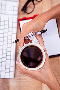 拥有黑咖啡杯的女商务人士电脑手指杯子饮料商务职业商业工作桌子议程图片
