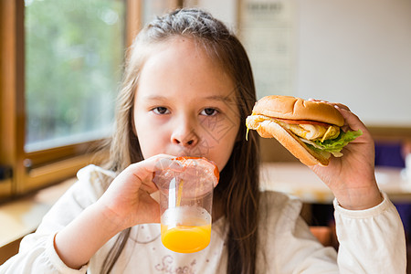 有汉堡包和橙汁的女孩孩子橙子果汁玻璃饮食水果女性女士食物美丽图片