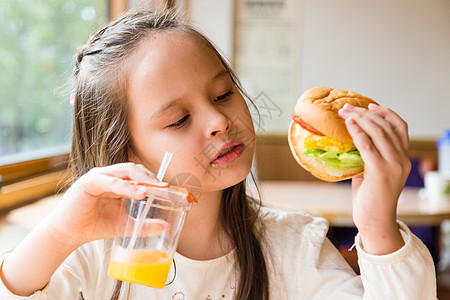 有汉堡包和橙汁的女孩食物水果孩子美丽女性饮食橙子女士果汁玻璃图片