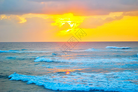 海岸的日落悬崖假期橙子蓝色天空旅行白色海滩太阳海洋图片