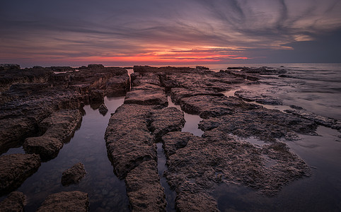 日落在海面上海洋海浪海岸蓝色石头风景橙子魔法地平线反射图片