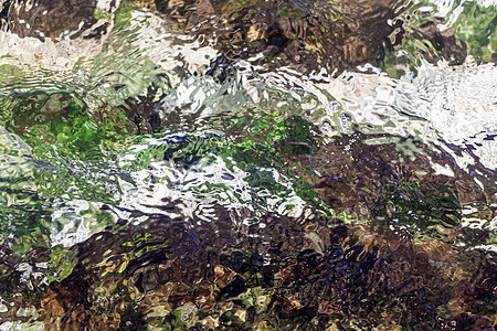 在不同的彩色岩石上 作为抽象的水背景波纹公园季节反射水池宏观海洋运动辉光池塘图片
