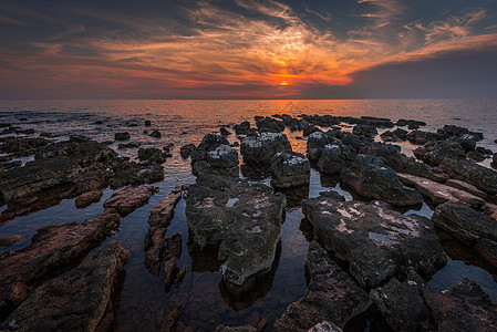 日落在海面上太阳海滩海浪海洋海岸反射岩石海景天际地平线图片