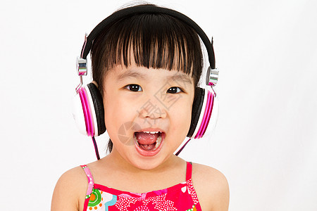 使用耳机的中国小女孩微笑闲暇女性旋律孩子们情感音乐家工作室女孩幸福背景图片