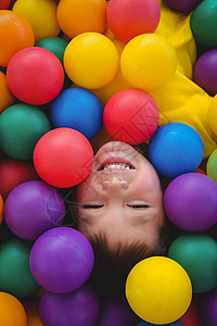 在海绵球池里笑笑可爱的男孩混血男生娱乐性童年游戏快乐喜悦时间娱乐乐趣图片