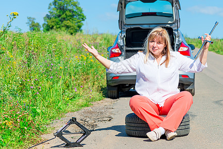 女司机坐在车坏掉的汽车附近的方向盘上坐着愤怒的女司机图片
