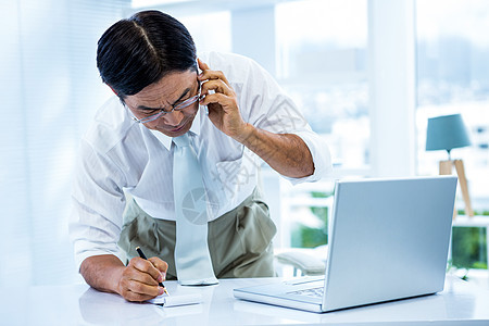 听电话和写字的商务人士被压倒在地的亚洲商务人士所击败人士职业套装旋转办公室商务专注男性男人沟通图片