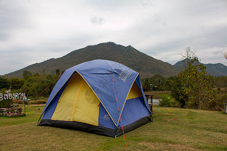 山中草地之间的难民营中的旅游帐篷公园乐趣森林木头假期顶峰树叶场地太阳日落图片