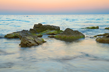 海洋中的岩石薄雾海滩蓝色日落地平线海岸季节太阳戏剧性石头图片