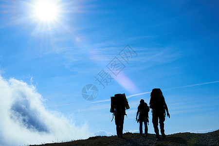 远足朋友的休眠爬坡女士游客冒险阳光天际悬崖自由旅行成就图片