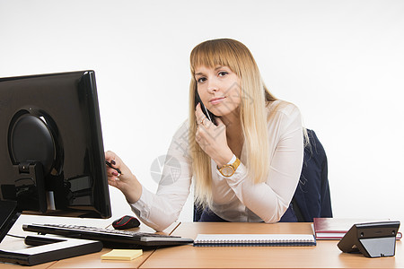 从事计算机工作的商业妇女 在电话上交谈和查看框架的商妇图片
