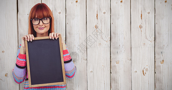 带着黑板的笑笑嬉马女人综合形象震惊快乐微笑红发服装木头针织品女士栅栏休闲图片