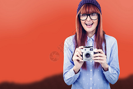 笑笑的时装女用反光照相机拍照的复合图像木头潮人天空毛线微笑边缘刘海相机红发山脉图片