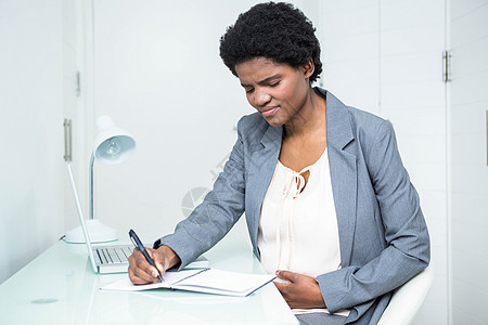 怀孕女商务人士在笔记本上写作办公室技术旋转黑色电脑女性套装职场腹部公司图片