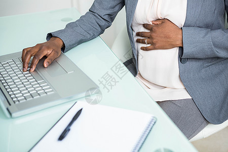 从事笔记本电脑工作的怀孕女商务人士女性套装桌子床单职场黑色技术旋转腹部人士图片
