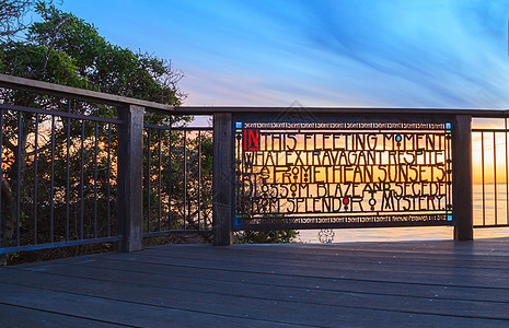 日落时在拉古纳海滩的有色玻璃围栏假期海洋公园海滩栅栏图片