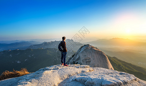 人类站在首尔Bukhansan国家公园的石头峰顶上图片