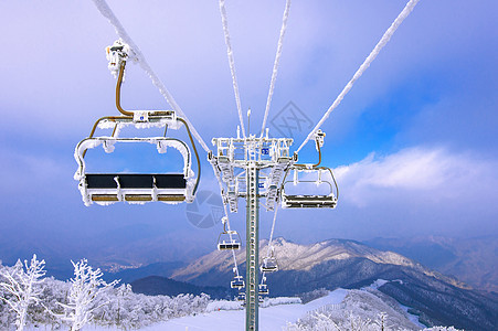 韩国冬季的雪堆覆盖着椅子升降机闲暇滑雪者娱乐索道乐趣木板休息冒险天空顶峰背景图片