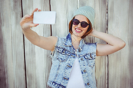 笑笑笑笑笑着的女人自拍潮人木头休闲手机享受羊毛帽子太阳镜服装微笑图片