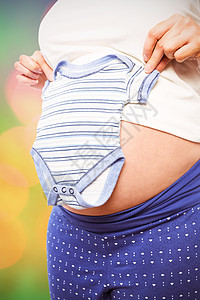 身着婴儿服装的怀孕妇女的综合图象绿色微光数字化橙子腹部护理睡衣孕妇装身体女性图片