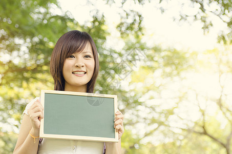 持有空白黑纸板的亚洲青年大学生女学生图片