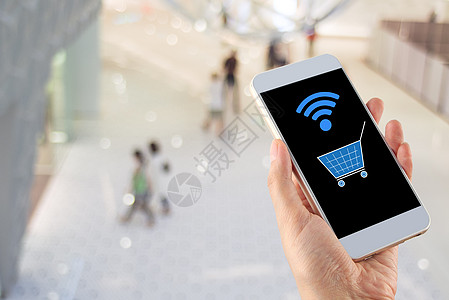 使用手智能手机购物车Wifi的模糊bokeh购物中心电子商务技术商业钱包支付电子电话女士大车指纹图片