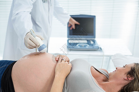 接受过超声波治疗的孕妇医师男人孕产屏幕考场技术制服医院肚子身体图片