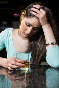 在酒吧柜台喝威士忌的压抑的女人思维混血派对女士服装夜生活夜店痛苦社交餐厅图片