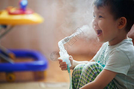吸入器小男孩在家里吸气 给支气管服药 通过管子呼出蒸汽背景